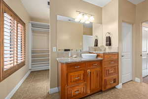 Bathroom featuring a spacious closet, vanity, and light tile patterned floors