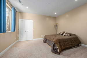 Carpeted bedroom with a closet and recessed lighting