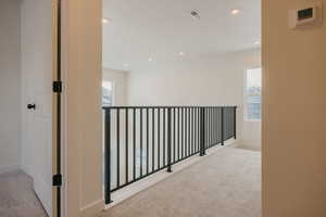 Hallway featuring light carpet and recessed lighting