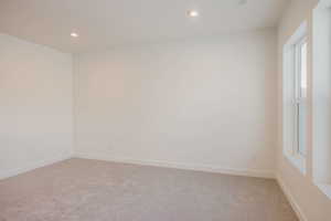 Spare room featuring light colored carpet and recessed lighting