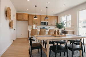 Dining room with light wood-style floors and recessed lighting