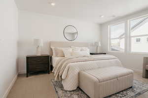 Bedroom with light colored carpet and recessed lighting