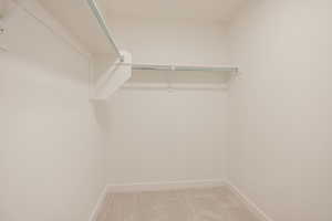 Walk in closet with light carpet
