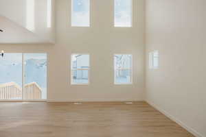Unfurnished room with light wood finished floors and a high ceiling