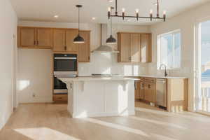 Kitchen featuring stainless steel appliances, a kitchen bar, tasteful backsplash, a center island, and light wood-style floors