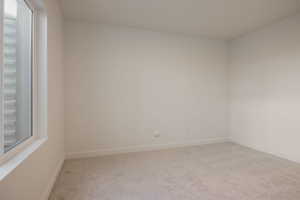 Empty room with light carpet and baseboards