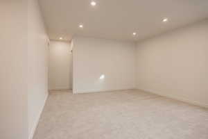 Unfurnished room with recessed lighting and light colored carpet
