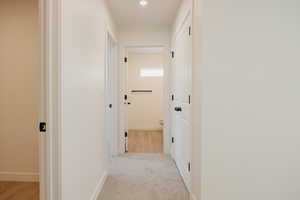 Hallway featuring light colored carpet and recessed lighting