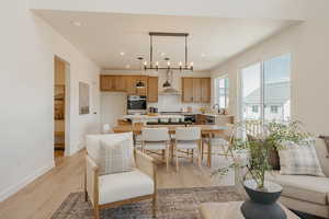 Kitchen featuring light countertops, light wood-type flooring, a center island, pendant lighting, and tasteful backsplash