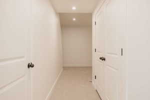 Hall with recessed lighting and light colored carpet