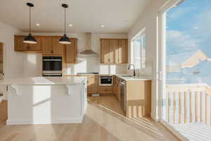 Kitchen featuring decorative backsplash, decorative light fixtures, light wood-style flooring, a breakfast bar, and a kitchen island
