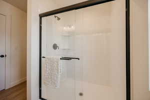 Full bath with a stall shower and wood finished floors