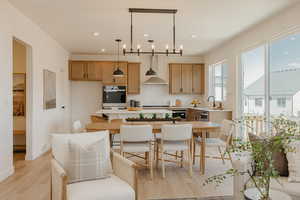 Kitchen with light countertops, decorative light fixtures, and light wood-style flooring
