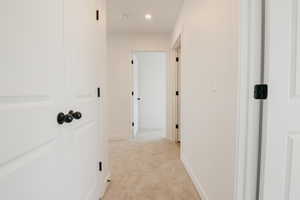 Hall featuring light carpet and recessed lighting