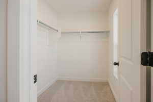 Walk in closet with light carpet
