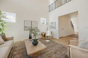 Living room with light wood-style flooring and a high ceiling