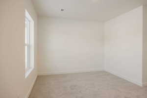 Unfurnished room featuring light colored carpet and baseboards