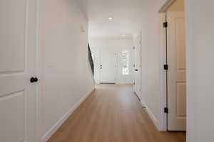 Hall featuring light wood finished floors and recessed lighting