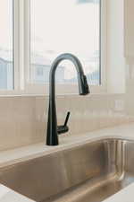 Kitchen view of a sink and light countertops