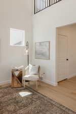 Sitting room with light wood-style flooring and a high ceiling