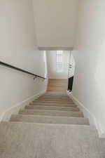 Staircase featuring wood finished floors and baseboards