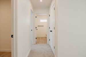 Hall featuring light carpet and recessed lighting