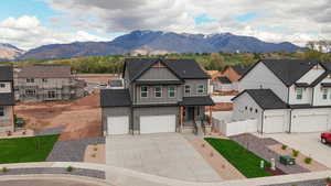 View of front of home with board and batten siding, a porch, roof with shingles, and a mountain view