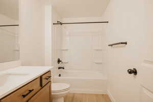 Full bathroom with vanity, light wood-type flooring, and shower / bathtub combination