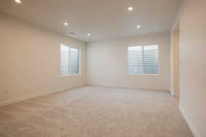 Empty room with recessed lighting and light colored carpet