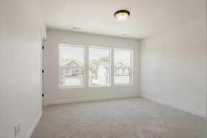 Empty room featuring light colored carpet and baseboards