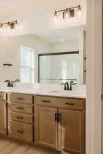 Bathroom featuring double vanity, light wood-style flooring, and recessed lighting