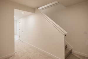 Stairway with carpet flooring and recessed lighting