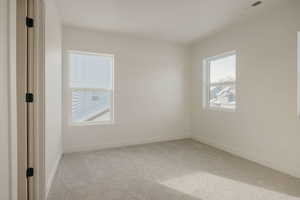 Unfurnished room with light colored carpet and baseboards