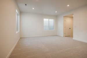Empty room with recessed lighting and light carpet