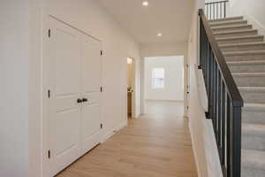 Hallway with recessed lighting and light wood-style floors
