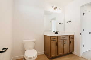 Half bath featuring vanity and light wood-style floors