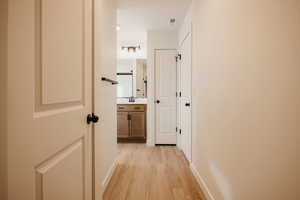 Corridor featuring light wood finished floors and baseboards