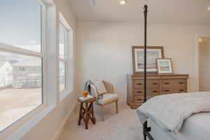 Bedroom with light colored carpet and recessed lighting