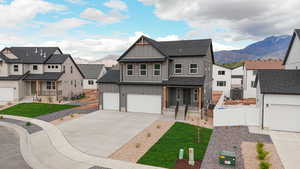 Modern farmhouse featuring board and batten siding, a mountain view, covered porch, a residential view, and a shingled roof