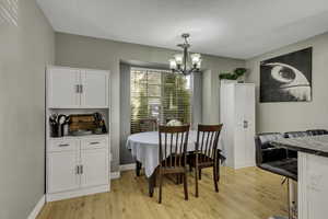 Dining room with light wood-style flooring and suspended lighting