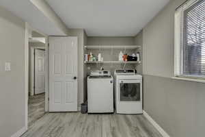 Laundry area with light wood-style floors and washer and dryer