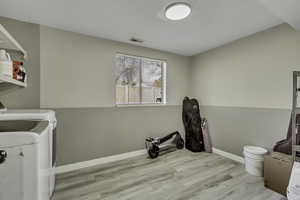 Large storage and Laundry room with LVP  wood-style floors and washer and dryer