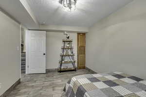 Bedroom with new paint, light, and a textured ceiling