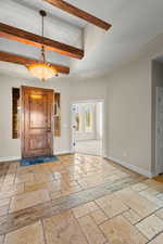 Entryway with stone tile flooring and baseboards