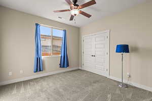 Unfurnished bedroom with carpet floors, a ceiling fan, and a closet