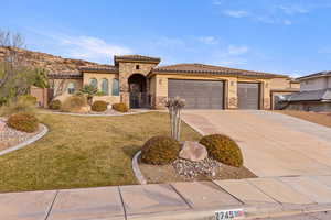 Mediterranean / spanish home featuring stone siding, stucco siding, driveway, an attached garage, and a tiled roof