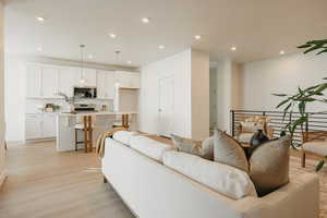 Living room with recessed lighting and light wood-style flooring