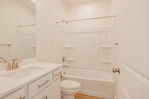 Full bathroom with bathtub / shower combination, vanity, and light wood-style flooring