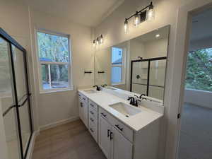 Bathroom featuring a shower stall and double vanity