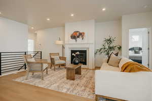 Living area featuring recessed lighting, light wood-type flooring, a tile fireplace, and plenty of natural light